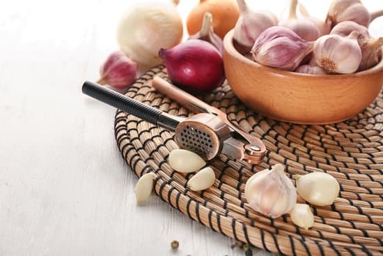canva garlic crusher and cloves on wicker mat MAD8SklP3YM