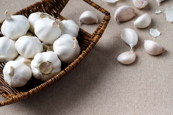 canva garlic in a wicker bowl and cloves on beige background MAEQS4DmMFY