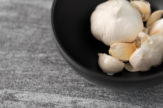 canva garlic in bowl on slate stone background MAEQQl0Acv4