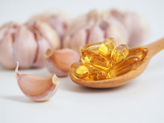 canva garlic with gel capsules on a spoon