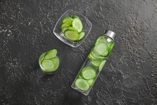 canva glass and bottle of cucumber infused water on a table MAD7FeZCGJM