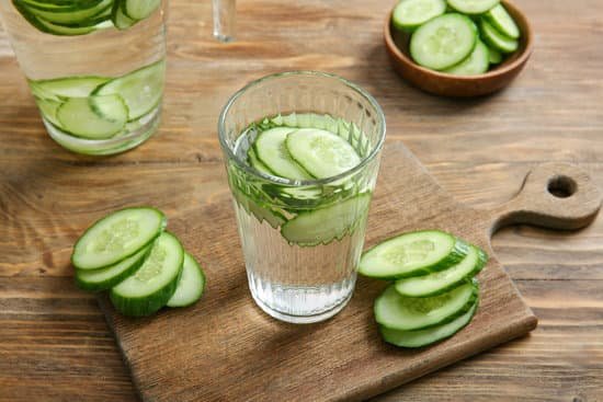 canva glass of cucumber infused water on a wooden table MAD7FVPOyl0