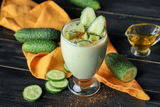 canva glass with cold cucumber soup on table