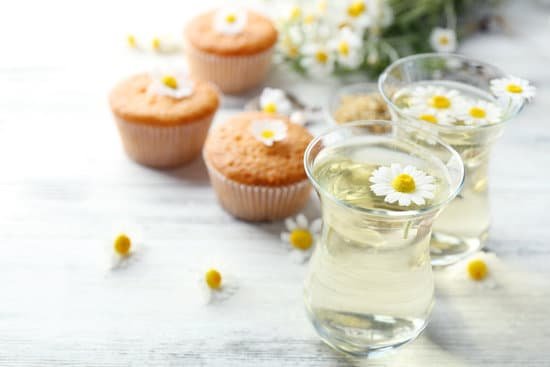 canva glasses of chamomile tea and muffins on wooden background MAD MZajn1w