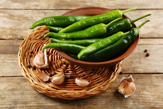 canva green peppers with garlic and peppercorns on wooden table MAD MuEytSI