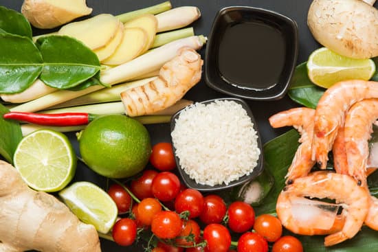 canva ingredients for authentic thai spicy soup tom yum kung. lime galangal red chili cherry tomato lemongrass and kaffir lime leaf on black. view from above. MAET5DrWT1o