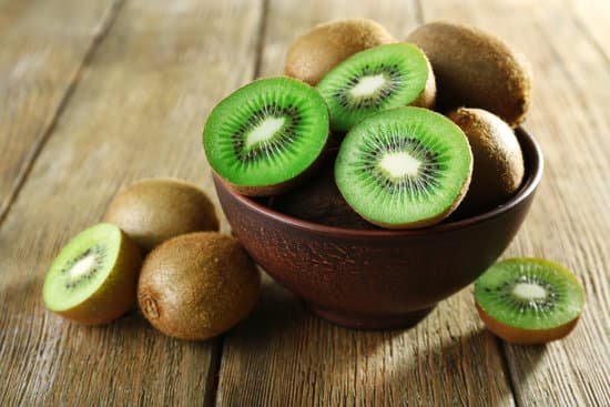 canva juicy kiwi fruit in bowl on wooden surface MAD MRKMXkM