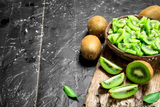 canva kiwi slices in a bowl on a cutting board. MAEPtp91238