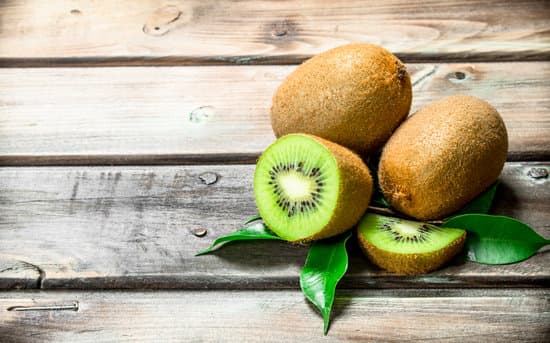 canva kiwis with leaves on a wooden table MAEPUVVhE1k