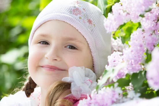 canva little girl posing near the branches of lilac MAD g7psFt4