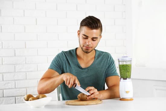 canva man cutting kiwi for smoothie MAD MnHmiEI