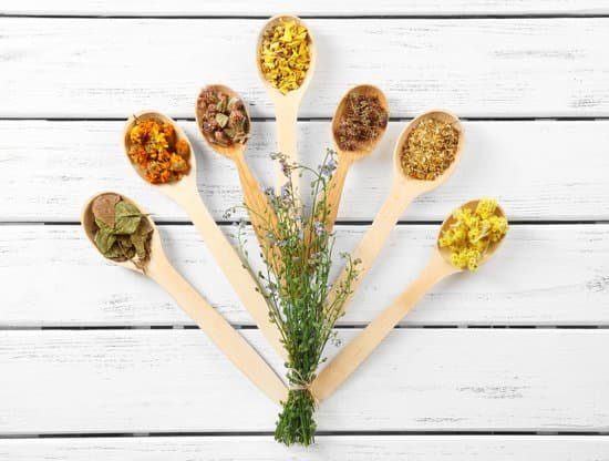 canva natural flowers and herb selection in wooden spoons on table MAD Q6r7BGY