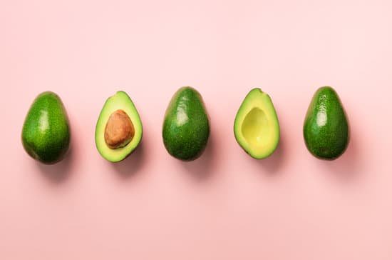 canva organic avocado with seed avocado halves and whole fruits on pink background MAC WSuJlbw