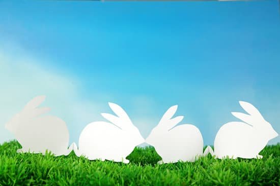canva paper easter rabbits on green grass on sky background MAD
