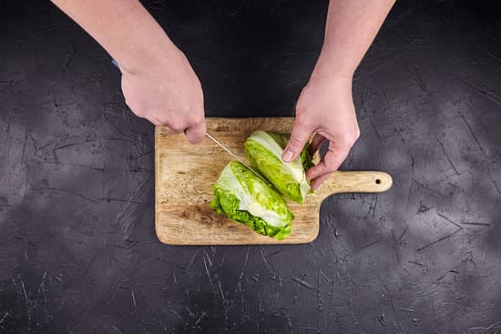 canva person cutting lettuce on wooden chopping board MAEN8j HwMc