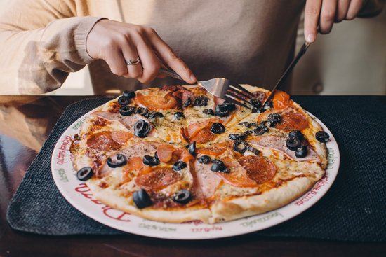 canva person eating pizza MADGyimqhr0