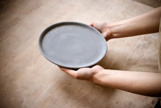 canva person holding an empty plate on a wooden table MAEZXvqoTJQ