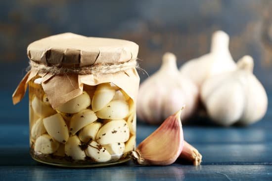 canva pickled garlic in a glass jar MAD MNam9jw