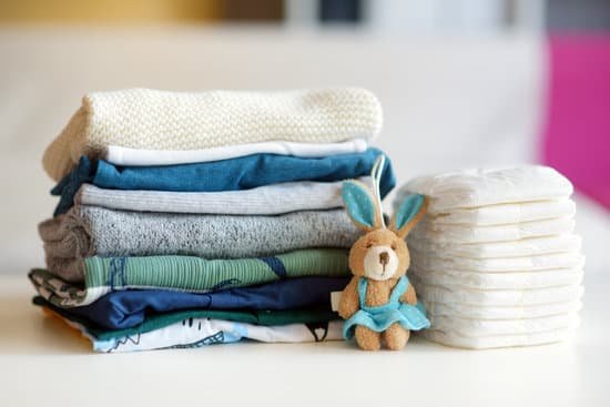 canva pile of baby clothes disposable diapers and a toy rabbit MAD vyC2lss