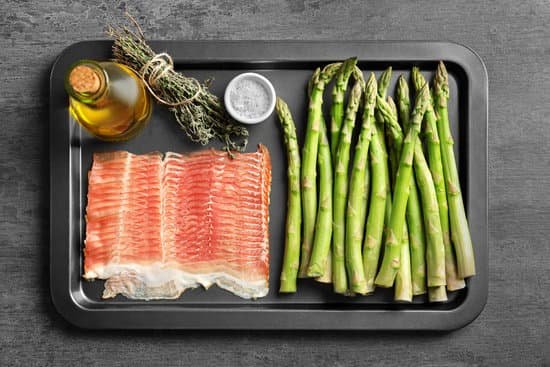 canva plate with asparagus and bacon on light background MAD9UN6BMJQ