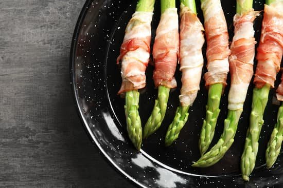 canva plate with bacon wrapped asparagus on light background MAD9UKG9B3E