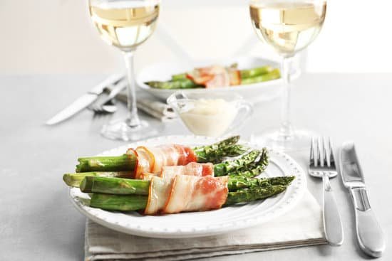 canva plate with bacon wrapped asparagus on table MAD9UME87OI
