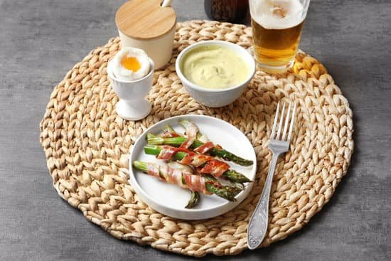 canva plate with bacon wrapped asparagus on wicker mat MAD9UMor74w