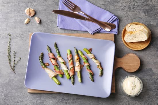 canva plate with bacon wrapped asparagus on wooden board MAD9UHWXoSg