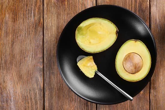 canva plate with fresh avocado on wooden background MAD QjbcZYg