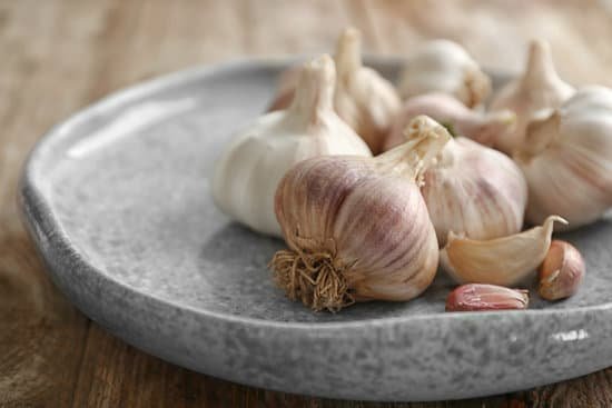 canva plate with fresh garlic on table MAD76nyPkNY
