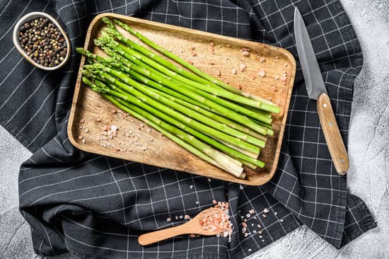 canva raw asparagus in a wooden bowl plate MAEQ8NhMZ0Y