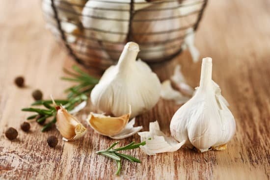 canva raw garlic and spices on wooden table MAD MJfRKrs