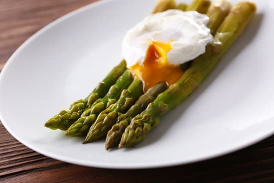 canva roasted asparagus with poached egg on plate on table MAD Md93bkk