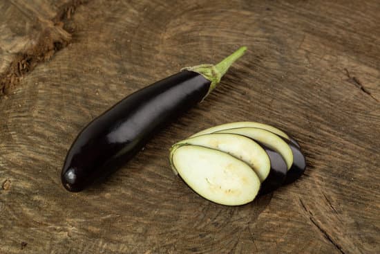 canva sliced and whole ripe eggplant on brown wooden desk MAD70ovNM3Q
