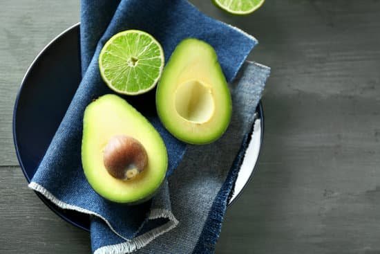 canva sliced avocado and lemon lime on wooden background MAD MaOkzOg