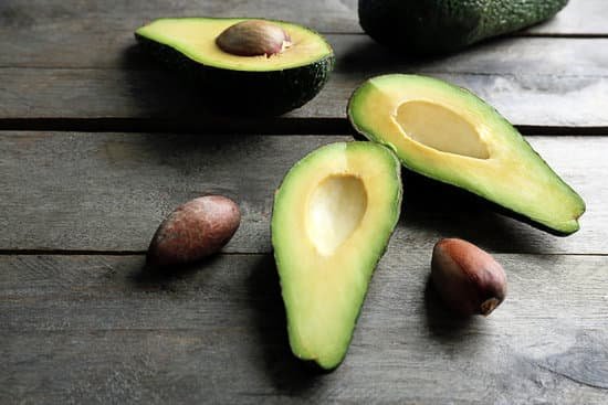 canva sliced avocado on a wooden table MAD QiKTiwQ