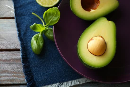 canva sliced avocado on plate on wooden background MAD MVhcFcg