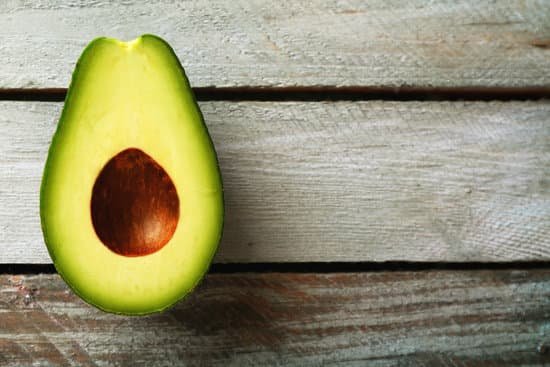 canva sliced avocado on wooden background MAD MaEugbw