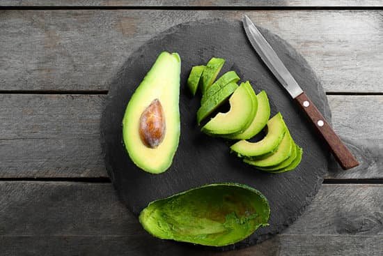 canva sliced avocado with knife on slate plate MAD QtRkTX4