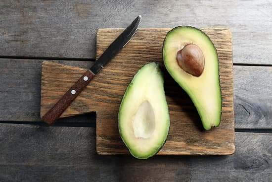canva sliced avocado with knife on wooden board MAD QjeM6i0