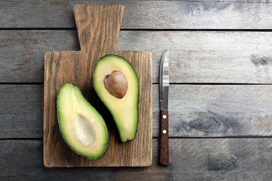 canva sliced avocado with knife on wooden cutting board MAD QlmveTg