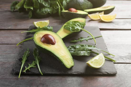 canva sliced avocado with lime and spinach on slate plate MAD QnBgz2U