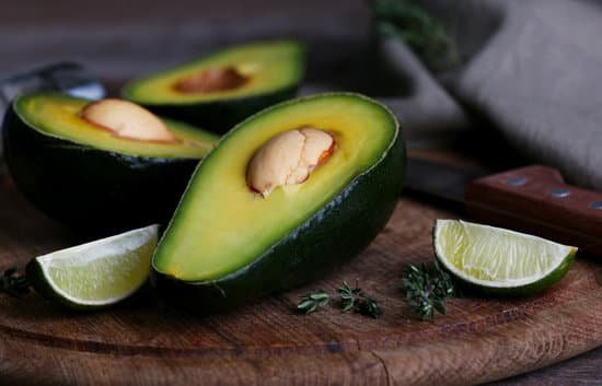 canva sliced avocado with lime on wooden cutting board MAD MFVtmiw