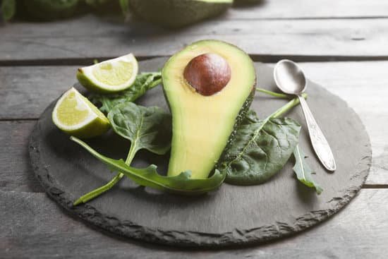 canva sliced avocado with lime spinach and arugula on slate plate MAD QngPcsA