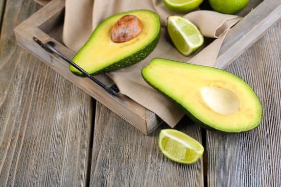 canva sliced avocado with limes on tray on wooden background MAD MEDiXMw