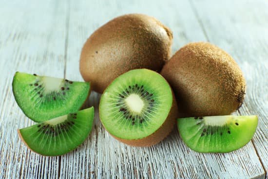 canva sliced kiwi fruit on a wooden table MAD MaGNj0I