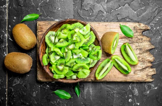 canva slices of kiwi in a wooden bowl flatlay MAEPeu0nmKw