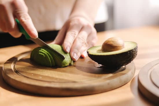 canva slicing avocado on wooden board MAERFTgMqTo