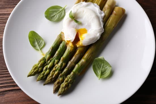 canva table with roasted asparagus with poached egg on plate MAD MTsLyB8