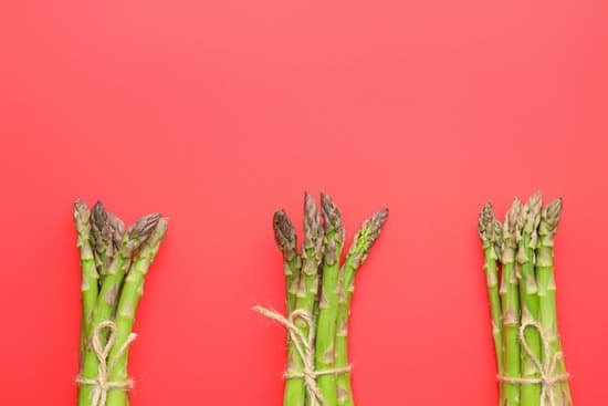 canva three bunches of asparagus on a red background MAD8y BJEkY